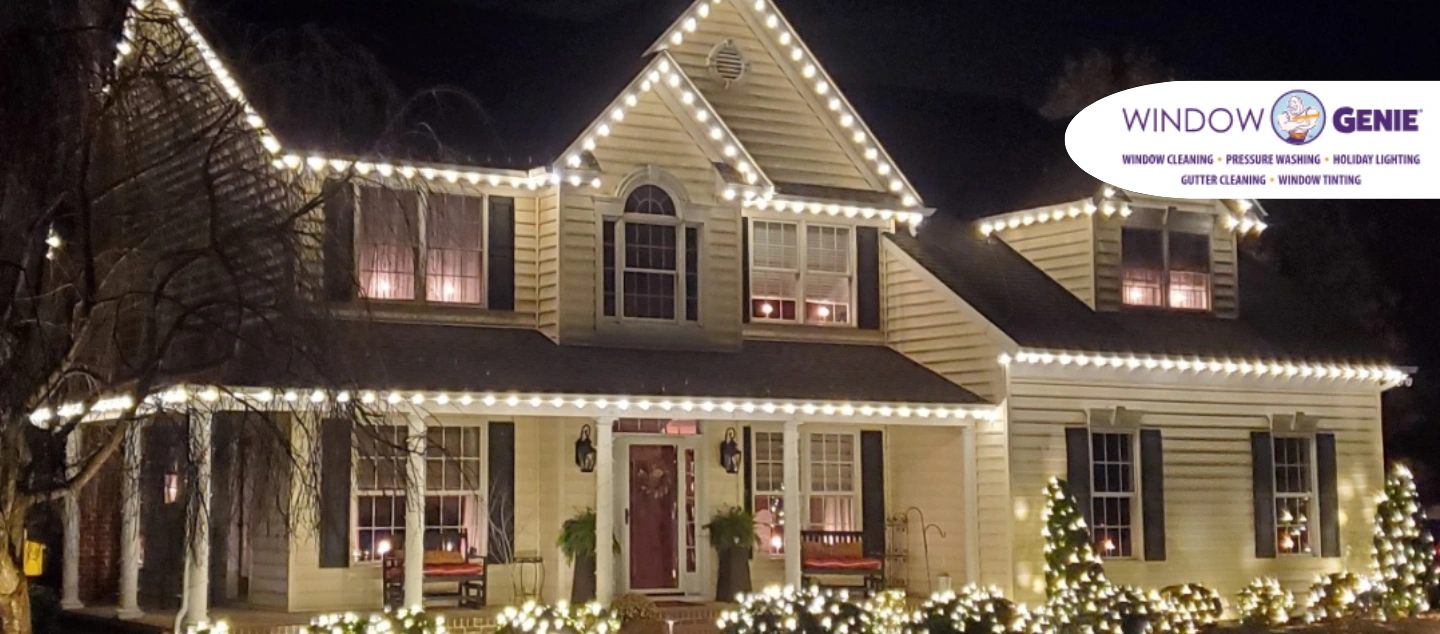 Large single-family home lit up by white holiday lights.