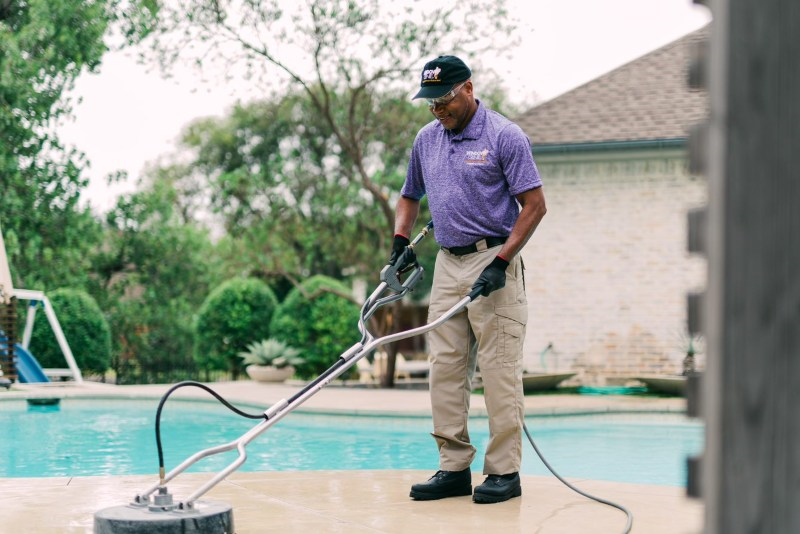 Window Genie Tech performing concrete cleaning