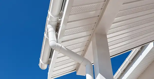 White gutters and large white eaves of a building's roof.