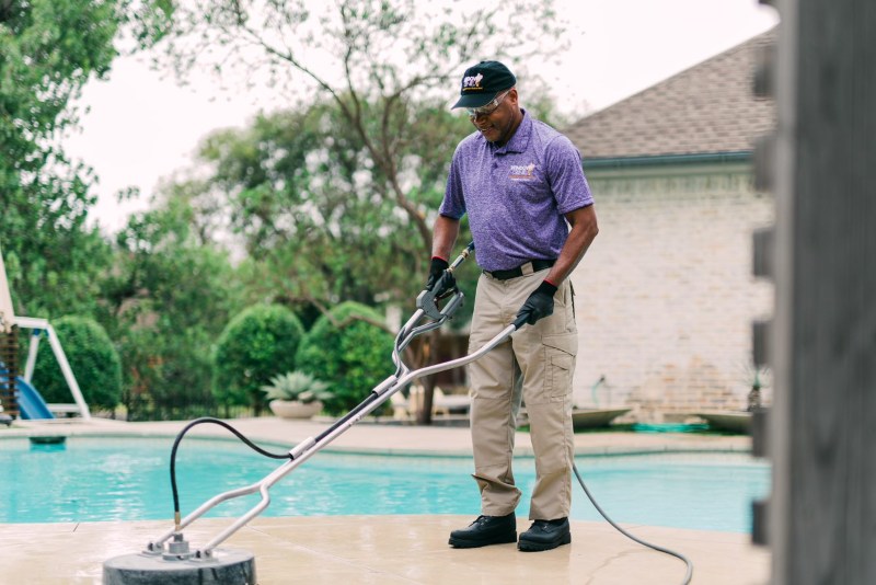 Window Genie Tech performing concrete cleaning 