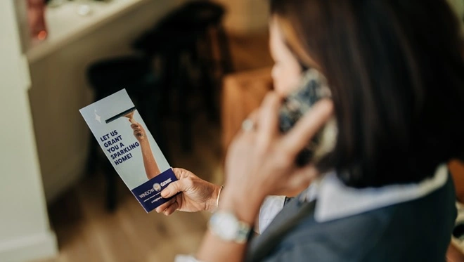 Woman contacting her local Window Genie on a cellphone. 