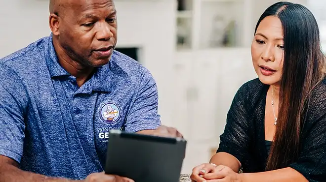 Window Genie service professional showing a tablet to a customer in her home.