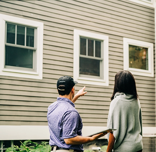 Window Genie Professional explaining window cleaning services to a customer.