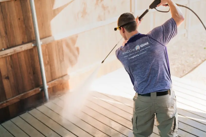 Window Genie professional pressure washing a wood deck.