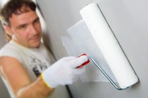 A man painting using a paint roller.