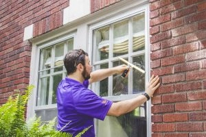 A window genie staff cleaning a window.