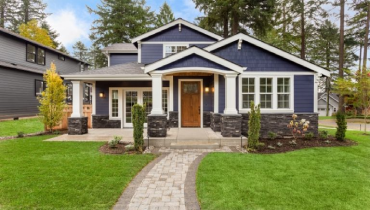 A charming blue house with white trim and a welcoming front porch.