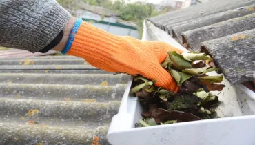 A person cleaning gutters.