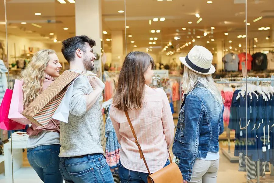 A group of people window shopping at a mall.